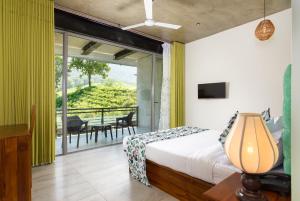 a bedroom with a bed and a balcony at Tara Waterfall in Rakwana