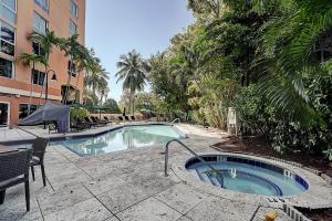 een zwembad met een tafel en stoelen naast een gebouw bij Coconut Grove Retreat 1 bedroom apartment with Bay views in Miami