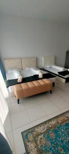 a bedroom with a bed and a couch and a rug at Camelia youth city nilai studio residence 5 pax. in Nilai