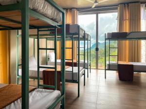 a group of bunk beds in a room with a window at Tara Waterfall in Rakwana