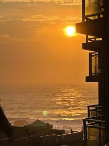 a sunset over the ocean from a building at Beachfront apartment in Ballito! Casablanca in Ballito