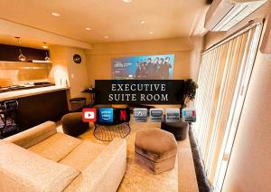 a living room with a couch and a tv at Stay Hakata in Fukuoka