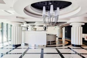 eine Lobby mit weißen Säulen und einem Kronleuchter in der Unterkunft ANS Hanza Tower Apartment No 701 - Swimming pool and saunas not opened from 12-28 November in Stettin + 34 Fotos