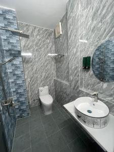 ein Bad mit einem Waschbecken und einem WC in der Unterkunft homestay 252 Long Hải in Ấp Lò Vôi
