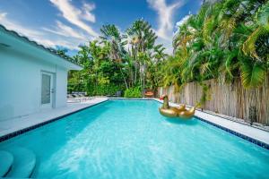- une piscine avec deux canards en caoutchouc dans l'eau dans l'établissement New Luxury Villa Delilah Biscayne Park, à Biscayne Park