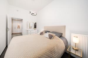 a white bedroom with a large bed with pillows at Hanza Tower Apartment no. 701 - Swimming pool, jacuzzi, terrace in Szczecin