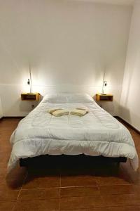 a bedroom with a bed with two towels on it at La Casa de al Lado entre el centro y el río, la Mejor Ubicación en Paraná in Paraná