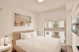 a white bedroom with a large bed and a window at Miami Sunset City View 1809 in Miami