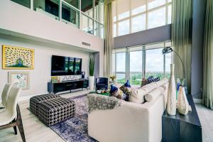 een woonkamer met een witte bank en een groot raam bij Luxury 2-story Penthouse located in Coconut Grove Hotel-includes Parking in Miami