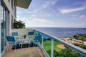 einen Balkon mit einem Tisch, Stühlen und Meerblick in der Unterkunft Luxury 2-story Penthouse located in Coconut Grove Hotel-includes Parking in Miami