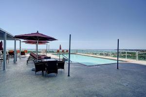 einen Pool mit einem Tisch, Stühlen und einem Sonnenschirm in der Unterkunft Luxury 2-story Penthouse located in Coconut Grove Hotel-includes Parking in Miami