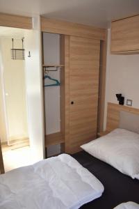 a bedroom with two beds and a door with a closet at Ferienhaus Chalet Ferienpark Lauwersoog NL in Lauwersoog