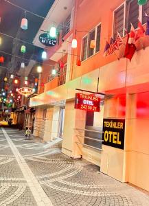 TEKİNLER OTEL في باليكسير: مبنى عليه لافتات على جانب شارع