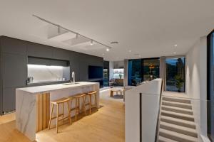 a kitchen with a counter and a kitchen island with bar stools at Station Bay Lodges - The Retreat in Lake Tekapo