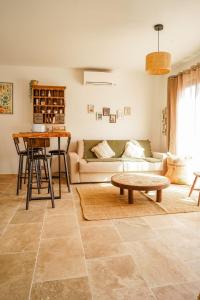 a living room with a couch and a table at Maison 47m2 à 10min des plages - billard, baby, salle de sport, jardin in Ajaccio