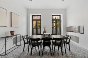 a dining room with a black table and chairs at Chelsea Canvas II by RoveTravel Large 3BR Duplex in New York