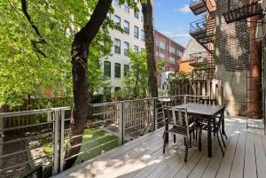 una terraza de madera con mesa y sillas. en Chelsea Canvas II by RoveTravel Large 3BR Duplex, en Nueva York