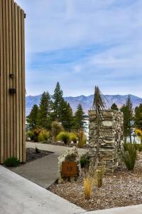 a garden with a stone house with mountains in the background at Station Bay Lodges - The Retreat in Lake Tekapo