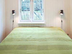 Bett in einem Zimmer mit zwei Lampen und einem Fenster in der Unterkunft Holiday home Grenaa XXXII in Grenå