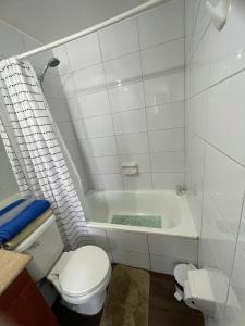 uma casa de banho com um WC e uma banheira em alojamiento city em Santiago