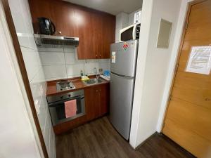 uma pequena cozinha com um frigorífico e um lavatório em alojamiento city em Santiago