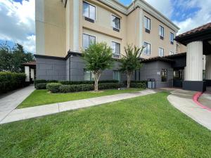 a large apartment building with a grass yard at Spark Suites Hobby Airport in Houston