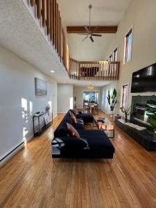 uma sala de estar com um sofá preto e uma lareira em Poconos Chalet -Kayaks- HotTub-Karaoke-Lake em East Stroudsburg