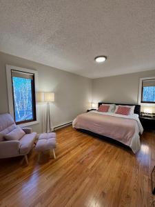 a bedroom with a bed and a couch and a chair at Poconos Chalet -Kayaks- HotTub-Karaoke-Lake in East Stroudsburg