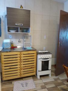 una pequeña cocina con fogones y fregadero en Hospedaria Ilhéus 04, en Ilhéus