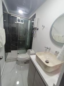 a bathroom with a sink and a toilet and a mirror at Hermosa habitación 202!! in Guatapé