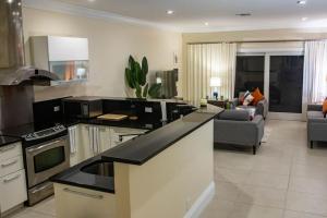 a kitchen with a counter top and a living room at Canal Front Comfort (Dock slip available) in Freeport
