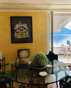 阿斯科納的住宿－BnB122 bed&breakfast，客厅配有玻璃桌和绘画作品