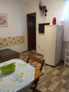 a living room with a table and a refrigerator at Hospedaria Ilhéus 04 in Ilhéus