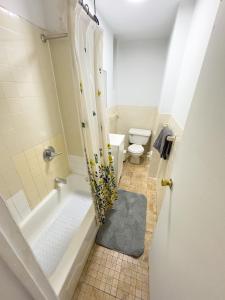 ein Bad mit einer Badewanne, einem WC und einer Dusche in der Unterkunft 1727-1RN 1Br with A shared Patio - UES in New York