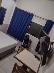 a room with a bed and a desk with a television at Hotel Music and Sports in Sao Paulo