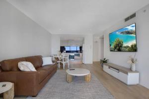 - un salon avec un canapé brun et une table dans l'établissement NEW! - Circle On Caville 33rd Floor Apartment Ocean Views, à Gold Coast