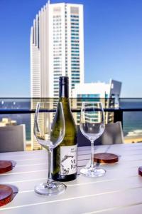 - une bouteille de vin et deux verres sur une table dans l'établissement NEW! - Circle On Caville 33rd Floor Apartment Ocean Views, à Gold Coast