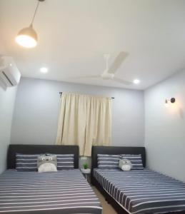 a room with two beds and a window at Pantai Remis Homestay 118A in Pantai Remis