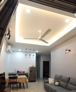 a living room with a ceiling fan and a couch at Pantai Remis Homestay 118A in Pantai Remis