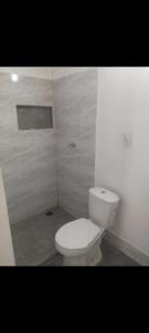 a bathroom with a white toilet in a room at Villa del sueño in Olaya