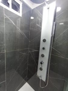baño con ducha de azulejos negros en Hermosa habitación 202!!, en Guatapé