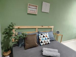 ein Schlafzimmer mit einem Bett mit Kissen und einer Pflanze in der Unterkunft Suite Us Guesthouse Kubang Kerian in Kota Bharu
