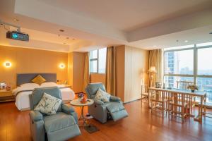 ein Hotelzimmer mit einem Bett und zwei Stühlen in der Unterkunft Green Island Holiday Hotel in Jiangmen