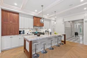 ニューヨークにあるRiverside by Rove Travel 7BR Modern Townhouseの白いキャビネットと大きな島のある広いキッチンが備わります。