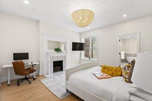 - un salon blanc avec un lit et un bureau dans l'établissement Riverside by Rove Travel 7BR Modern Townhouse, à New York