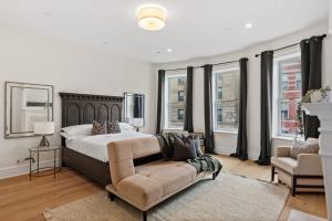 ein Schlafzimmer mit einem großen Bett und einem Sofa in der Unterkunft Riverside by Rove Travel 7BR Modern Townhouse in New York