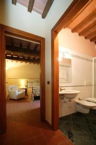 ein Bad mit einem Waschbecken und einem WC sowie ein Schlafzimmer in der Unterkunft Appartement in Figline Valdarno mit gemeinsamem Pool, Grill und Terrasse in Figline Valdarno