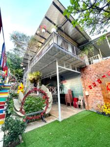 a house with a patio with a balcony and a lawn at Lake view homestay in Pleiku