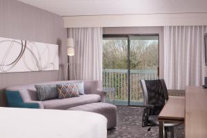 a hotel room with a bed and a couch and a table at Courtyard Greenville-Spartanburg Airport in Greenville