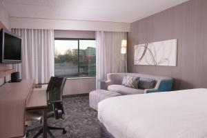 a hotel room with a bed and a desk with a computer at Courtyard Greenville-Spartanburg Airport in Greenville